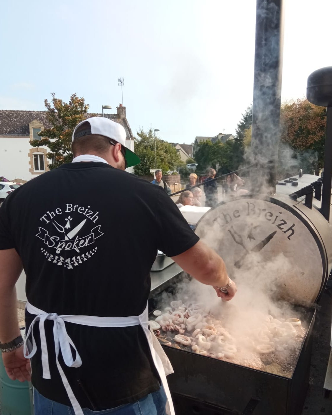 photo de dos du chef traiteur barbecue Damien Jouan, avec son smoker am&eacute;ricain, faisant un atelier barbecue flambage
